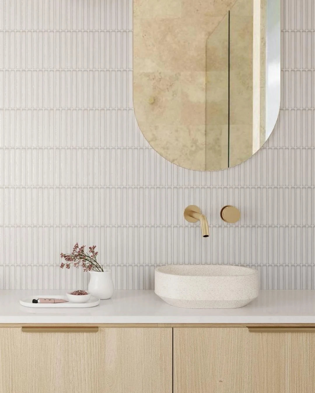 Bathroom with round mirror, sink, and decorative elements on a light-colored wall.
