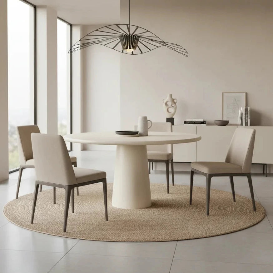 Modern dining room with a round table and chairs in a well-lit room.
