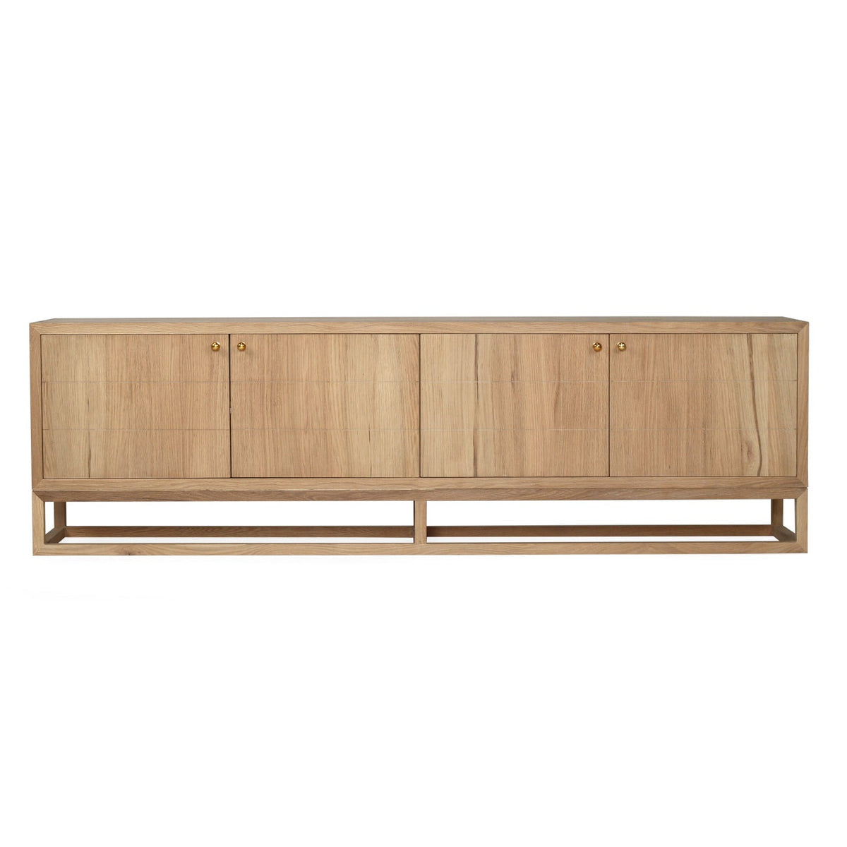 A modern sideboard cabinet made of light natural wood with four doors and small round brass handles, supported by a low open frame base, shown against a plain white background.