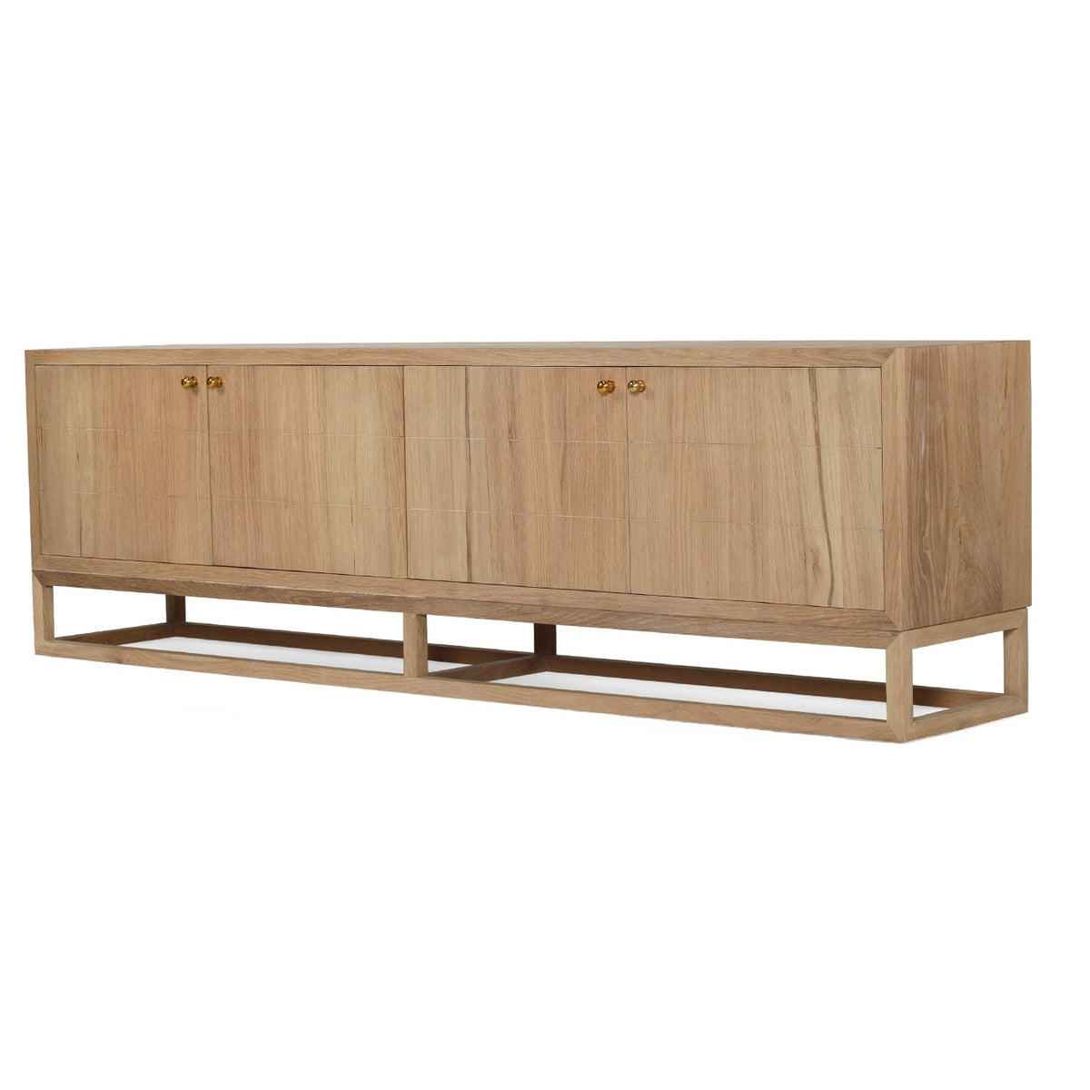 A mid-century modern sideboard cabinet made of light natural oak wood, featuring four doors with small brass knobs and a low open metal frame base, shown against a plain white background.