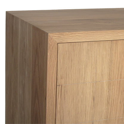 Close-up of a light oak wood cabinet corner showing the top surface, front panel, and side edge against a white background.