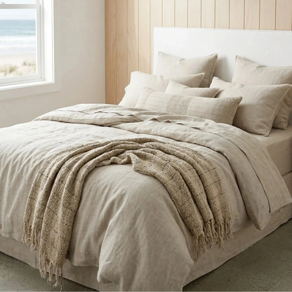 Neatly made bed with beige bedding in a bedroom with wooden walls and a window.