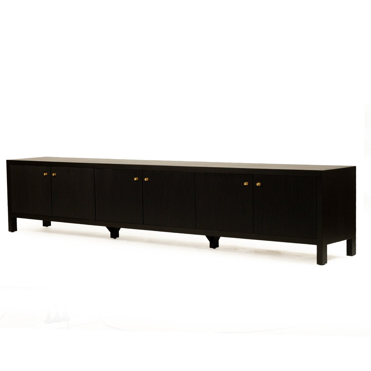 A long black sideboard or credenza with six cabinet doors and small round gold knobs, photographed against a plain white studio background.