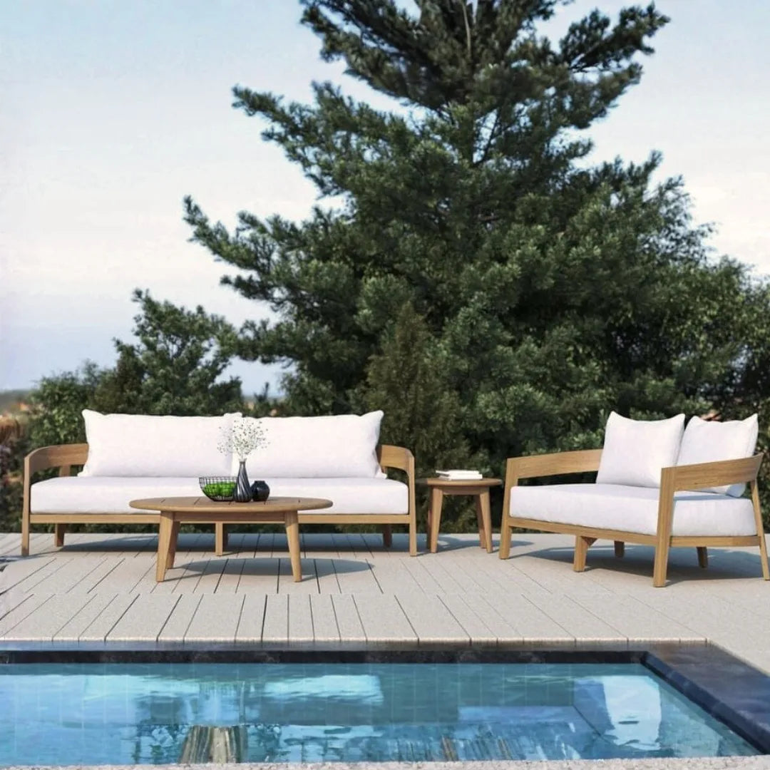 Outdoor furniture set with white cushions by a poolside