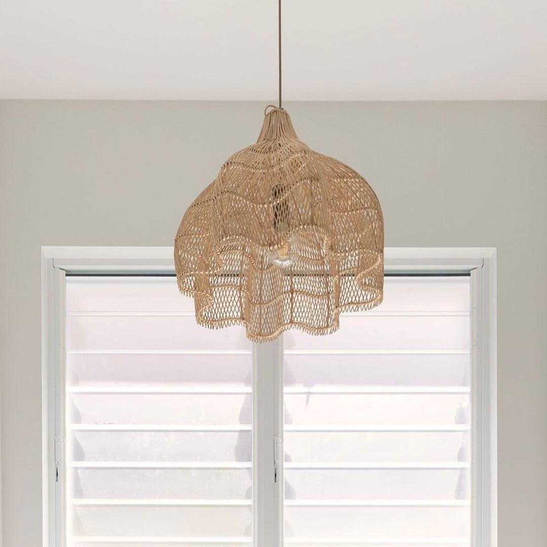 Lotus woven rattan pendant light from sun republic hanging in front of a window with white blinds.