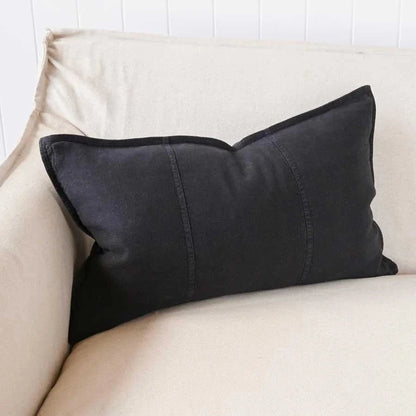 Black pillow on a beige sofa.