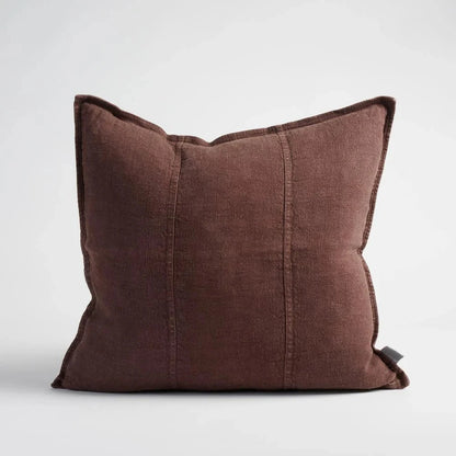 Brown pillow with textured edges on a light gray background