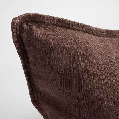 Close-up of a brown textured pillow on a plain background.