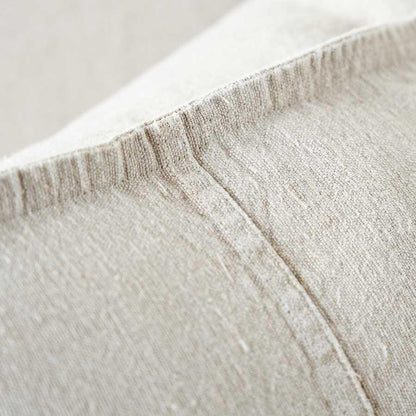 Close-up of textured beige fabric with a focus on the stitching and weave.