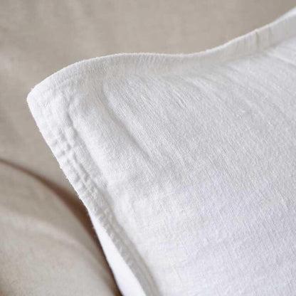 Close-up of a white textured pillow on a beige background.
