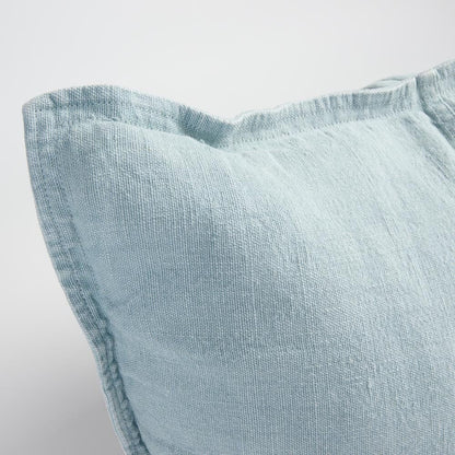 Light blue textured pillow on a neutral background