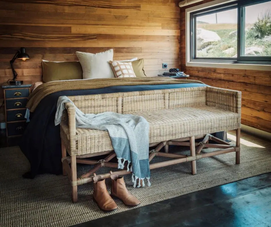 Cozy bedroom with wooden walls, a bed, and a bench.