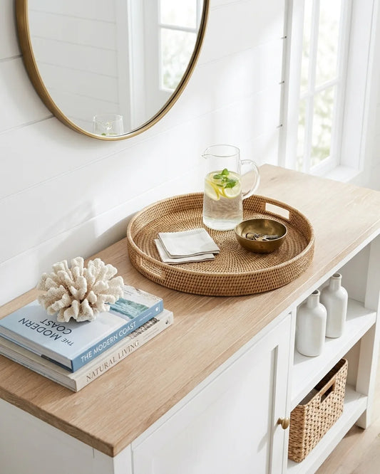 Wooden console table with a wicker tray, books, and decorative items in a bright room.