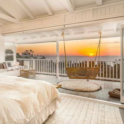 Cozy bedroom with a view of a sunset over water