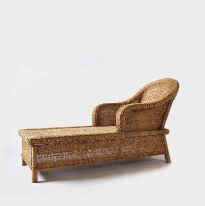 Woven cane sunlounge chair on a white background