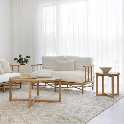 Modern living room with white sofas, wooden coffee table, and decorative items.