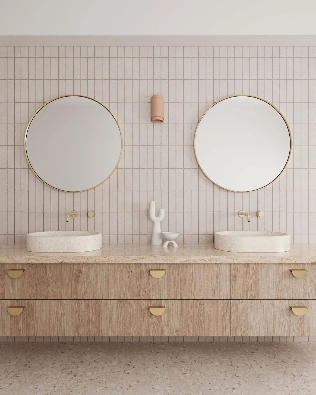 Bathroom vanity with two round mirrors, white sinks, and wooden cabinets.