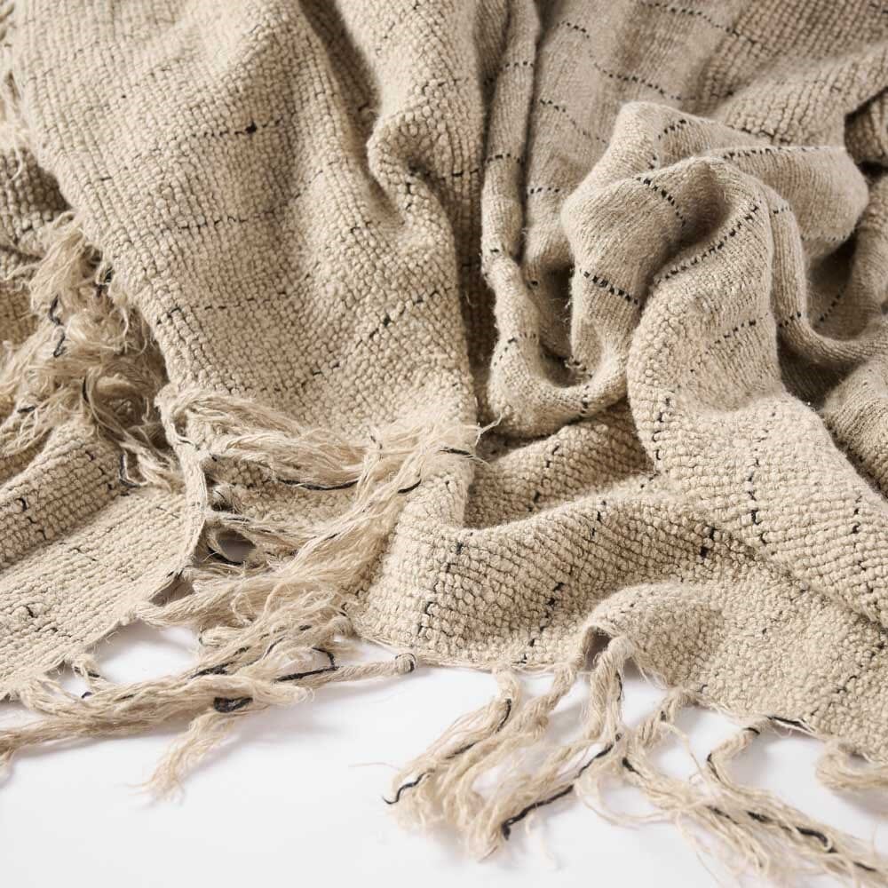 Beige textured blanket with tassels on a white background