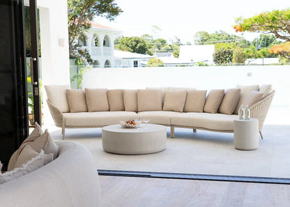 Modern outdoor patio with a beige sectional sofa and round coffee table.
