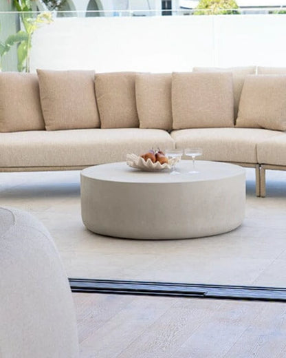 Beige sectional sofa with a round coffee table in an outdoor setting