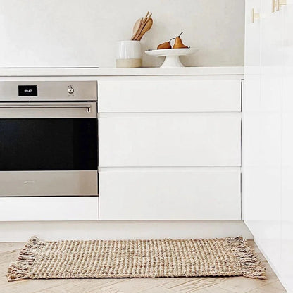 Modern kitchen with stainless steel oven and white cabinetry.