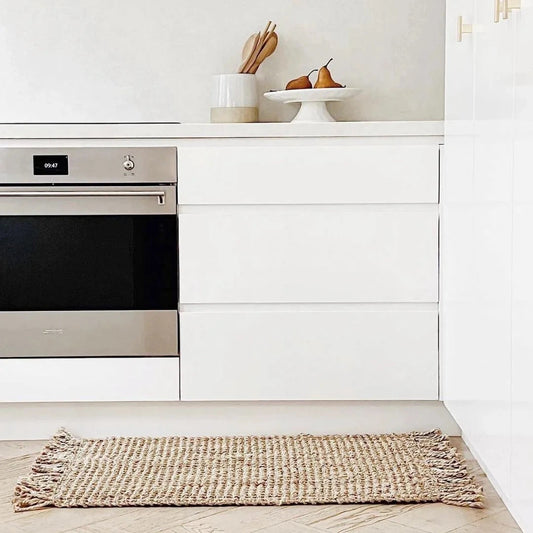Modern kitchen with stainless steel oven and white cabinetry.