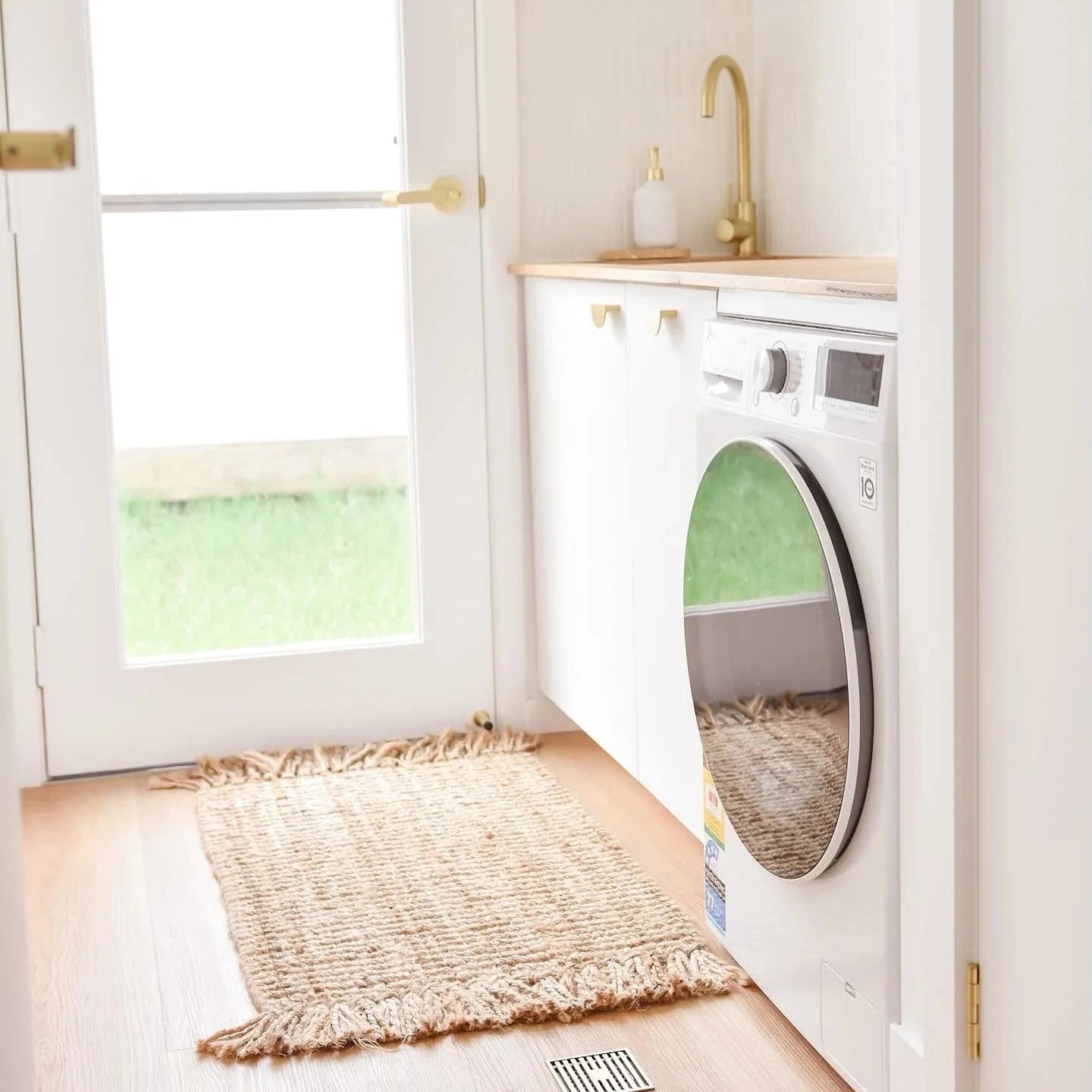 Modern laundry room with washer, dryer, and jute floor mat