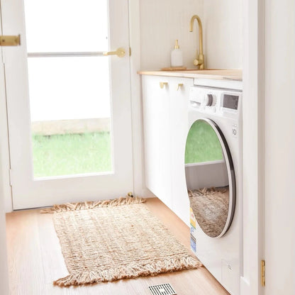 Modern laundry room with washer, dryer, and jute floor mat