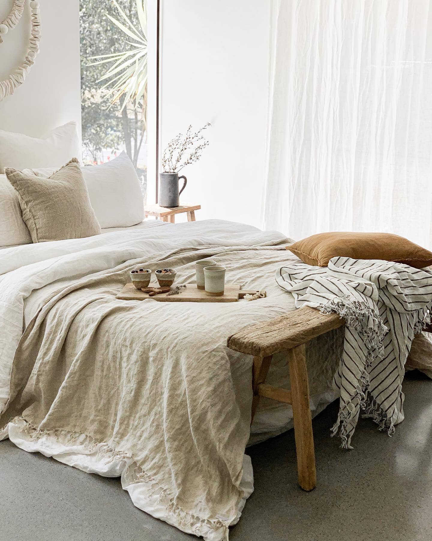 Cozy bedroom with a bed, wooden bench, and decorative items.