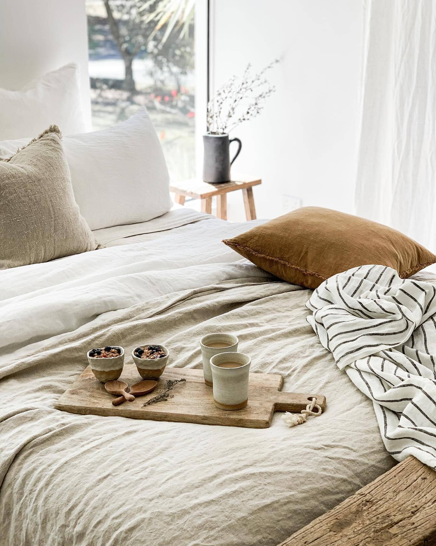 Cozy bedroom with a bed, pillows, and a tray with tea set.