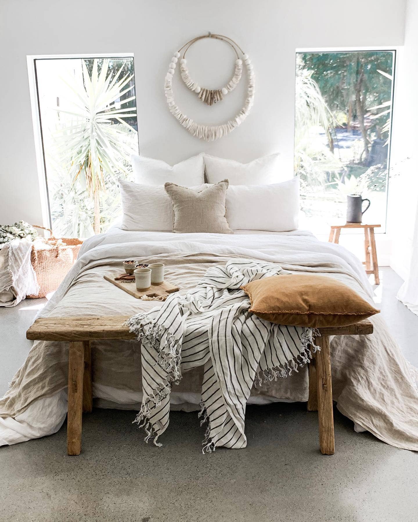 Cozy bedroom with a bed, wooden bench, and decorative elements.
