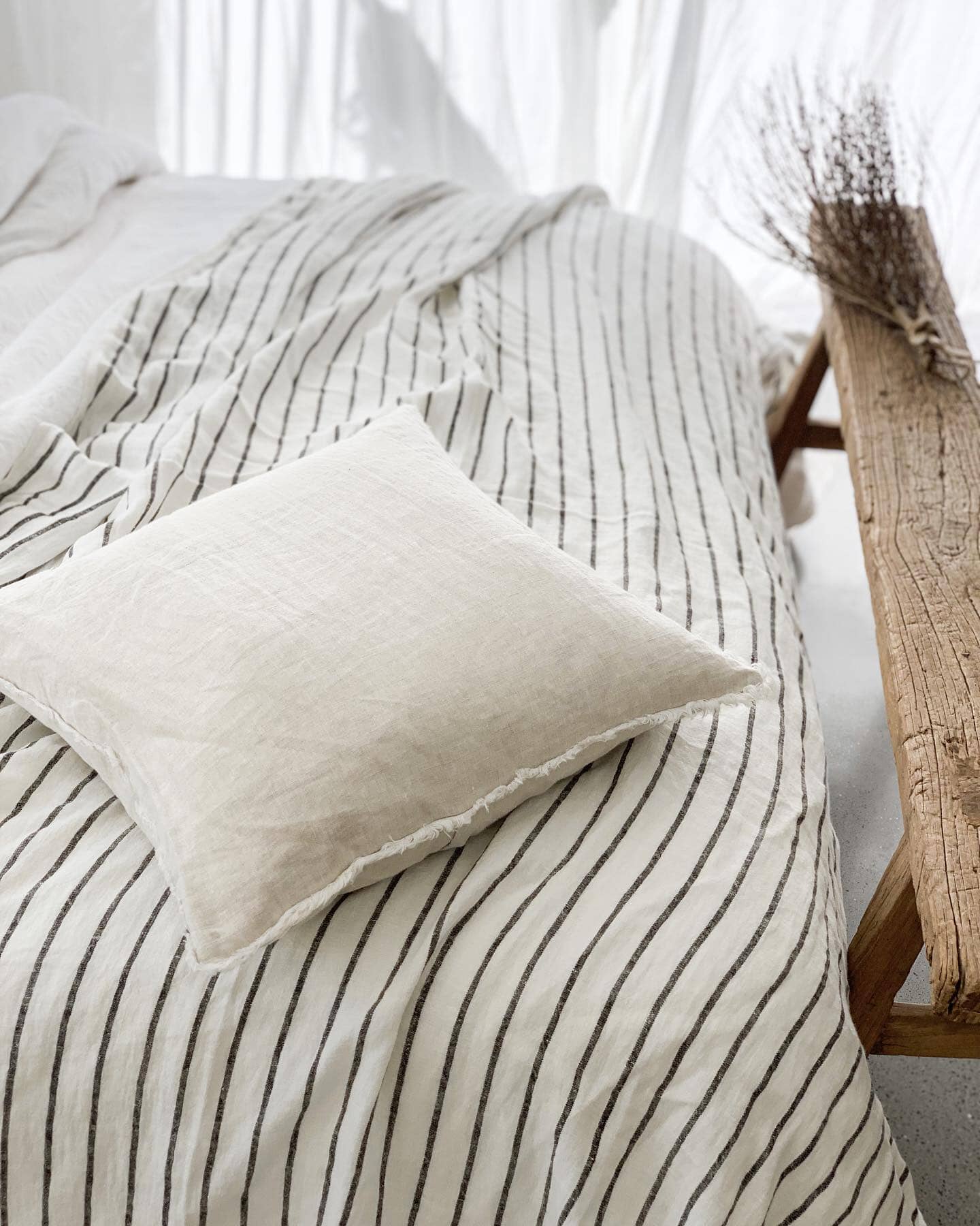 Striped bedding with a pillow on a bed in a softly lit room.