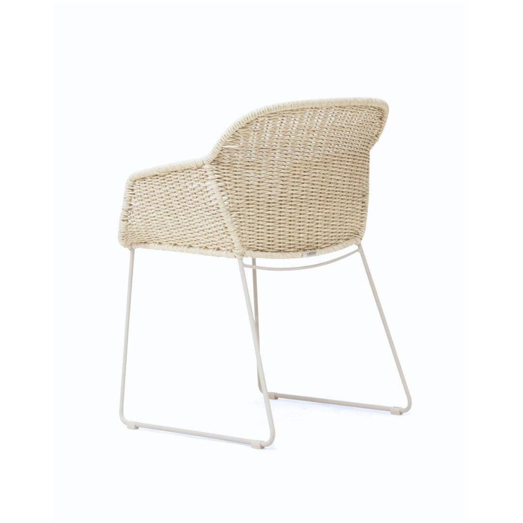 A modern outdoor armchair with a woven beige wicker seat and backrest, supported by a slim white metal frame, shown against a plain white background.