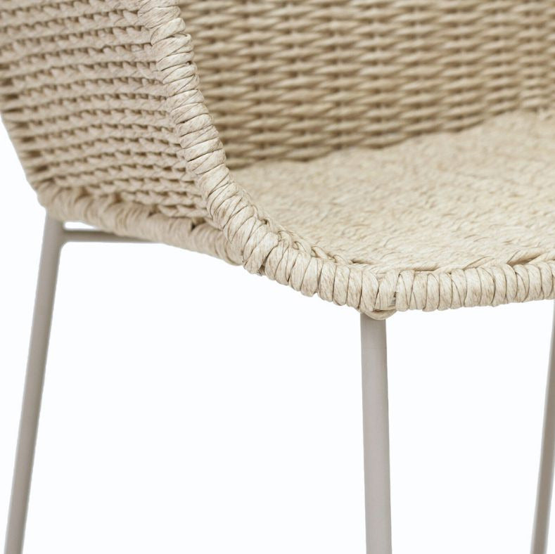 Close-up of a woven chair seat and back in a natural beige tone with thin white metal legs, shown against a plain white background.