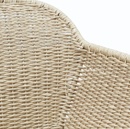 Close-up detail of a woven natural fiber product, showing the texture and curved edge on a white background.