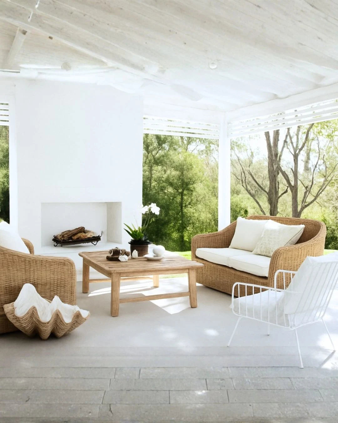 Modern outdoor living space with wicker furniture and a fireplace.