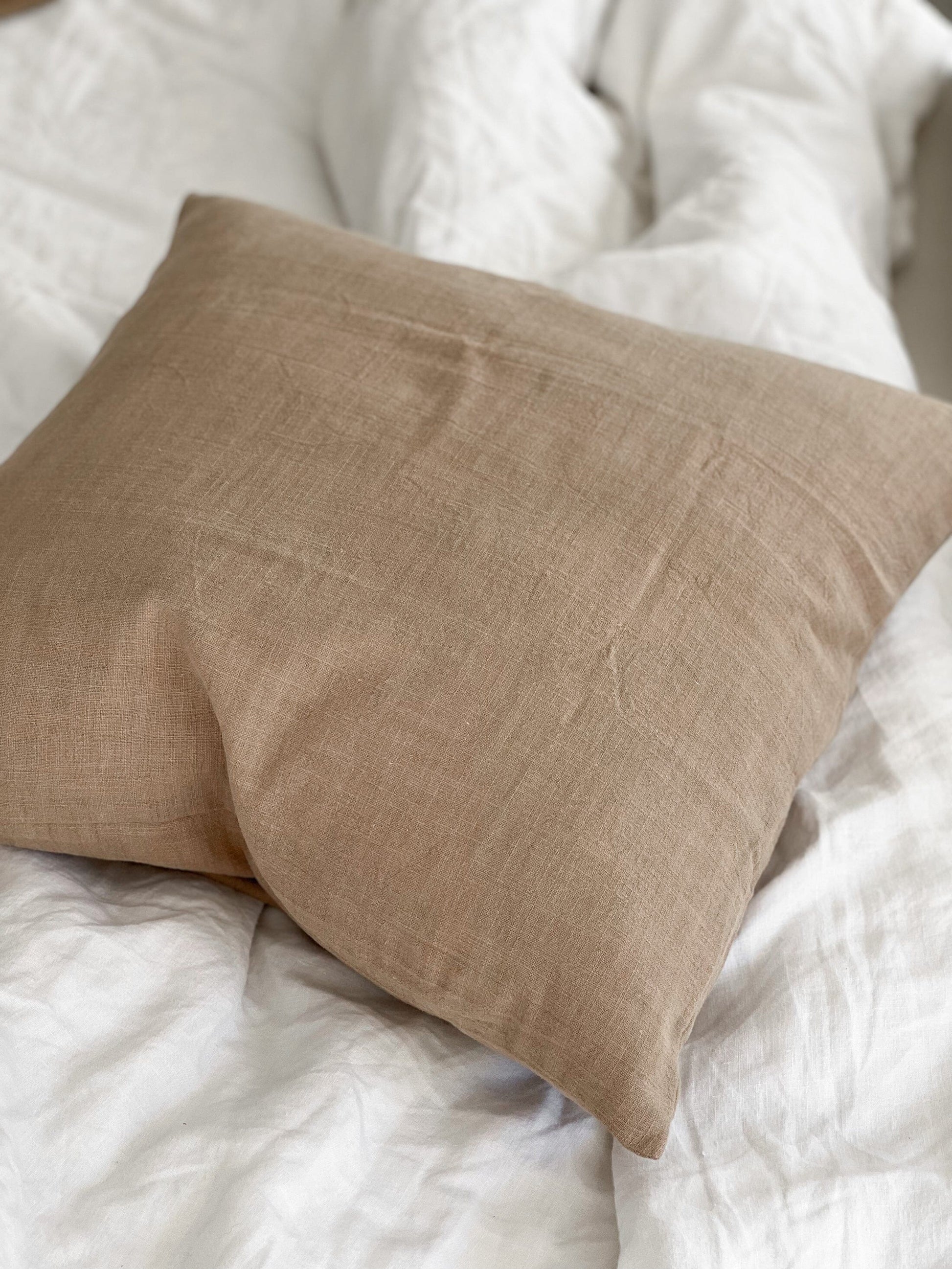Brown pillow on a white textured surface