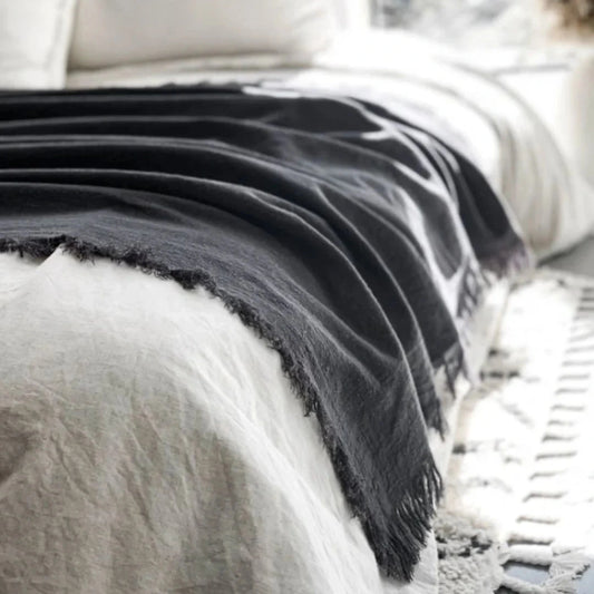 Black and white striped blanket on a bed with pillows