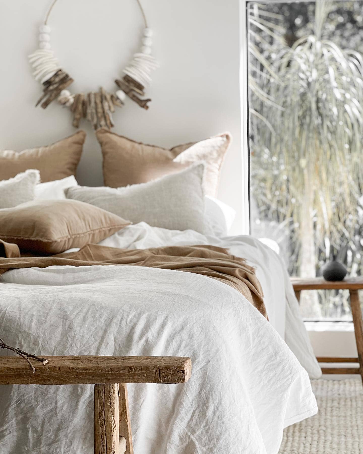 Cozy bedroom with a bed, pillows, and a wooden bench.