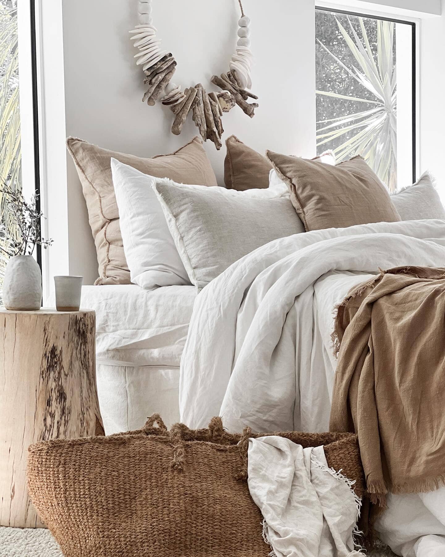 Cozy bedroom with neutral tones, pillows, and a woven basket.