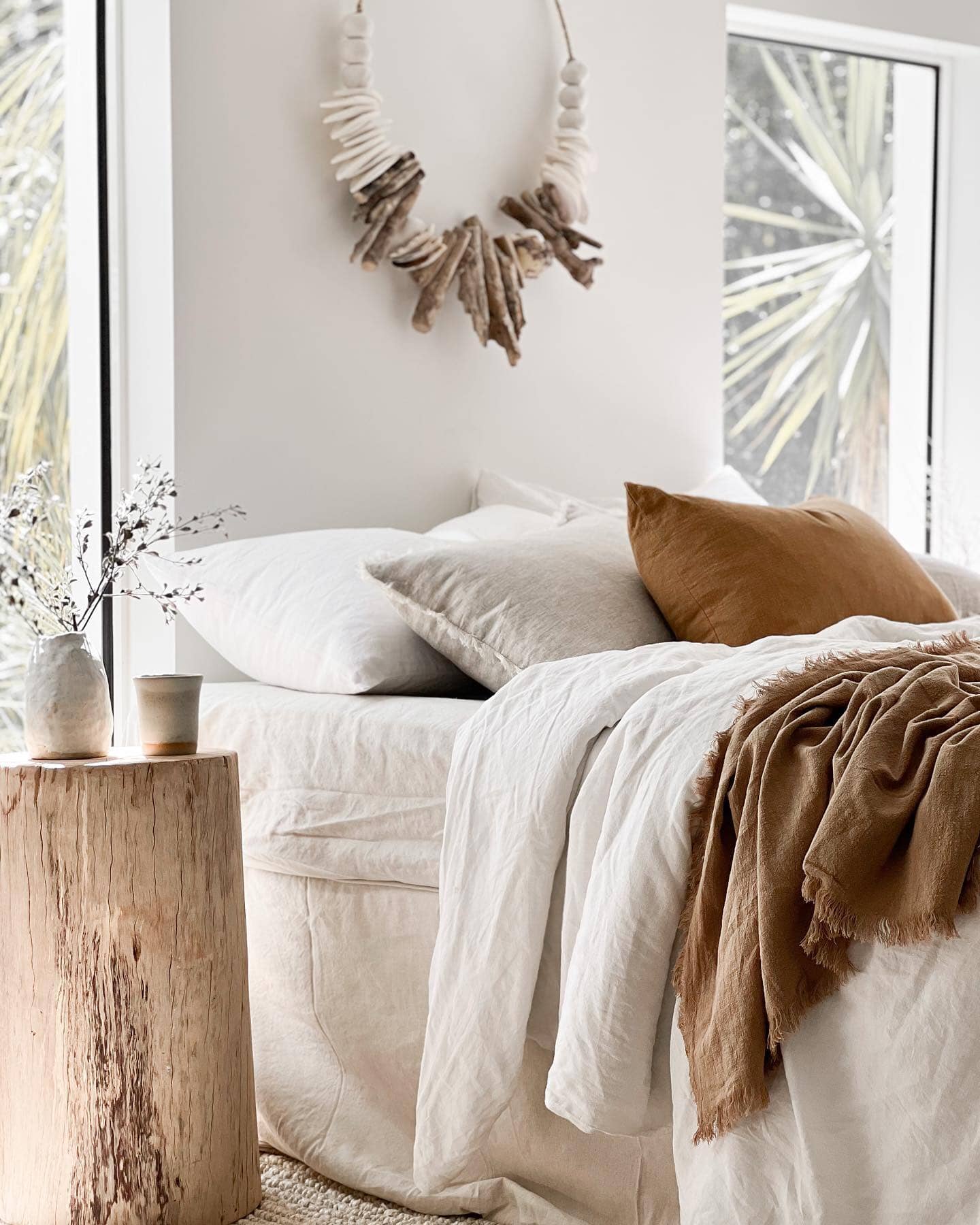 Cozy bedroom with a bed, pillows, and a decorative wreath on the wall.