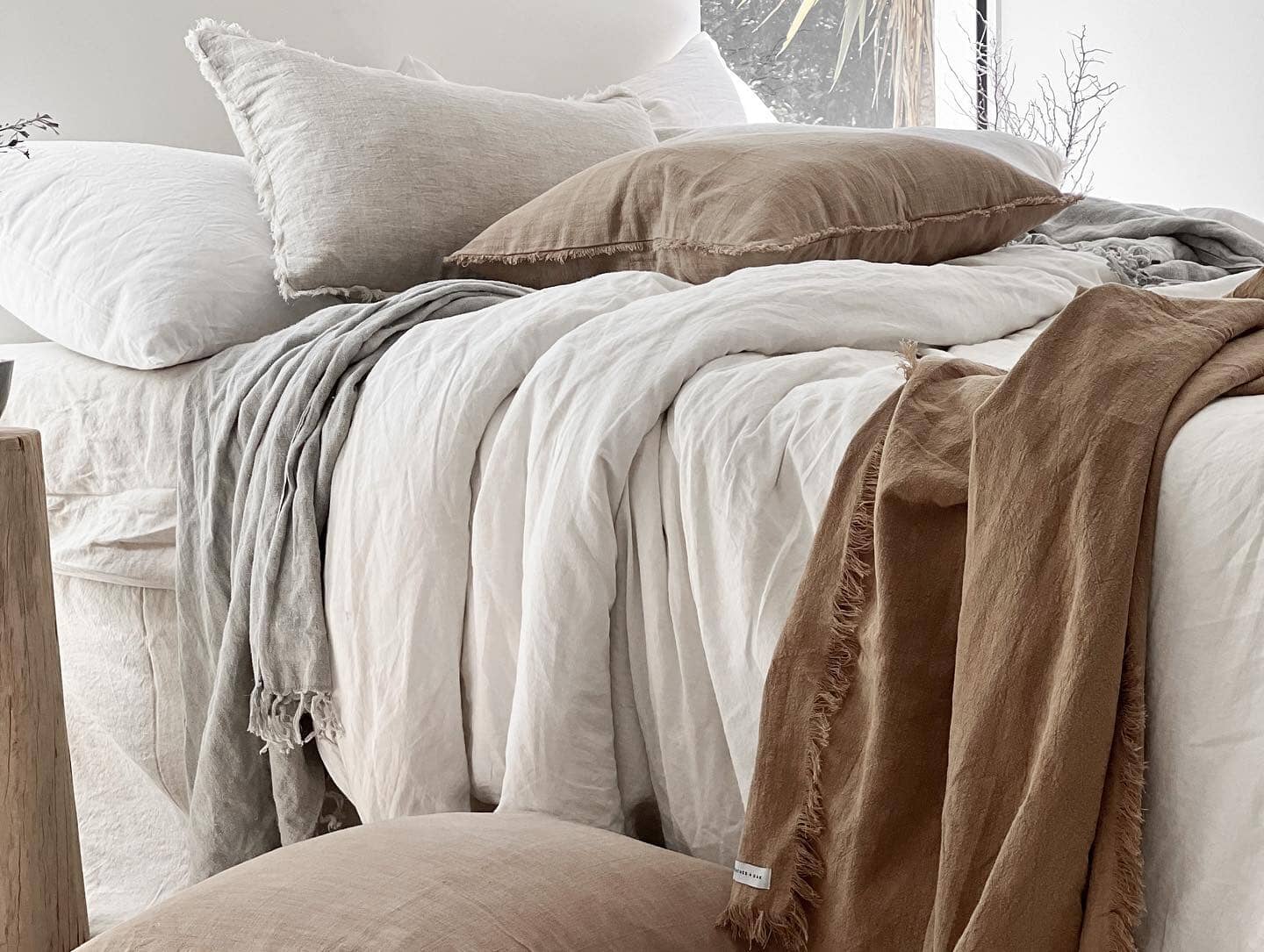 Cozy bed with beige and brown bedding in a softly lit room