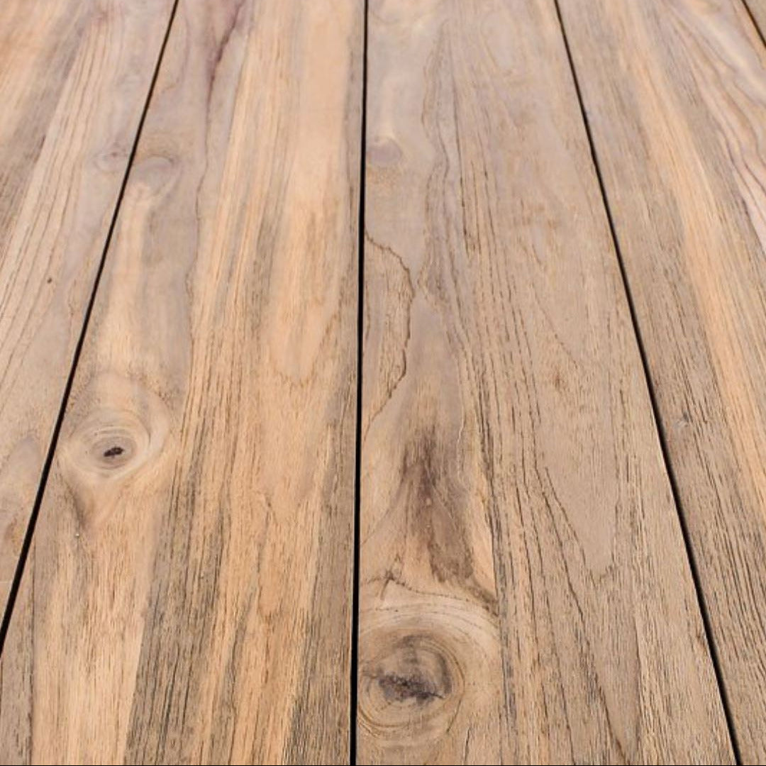 Close-up of natural wood planks with visible grain, knots, and a light brown to tan coloration.