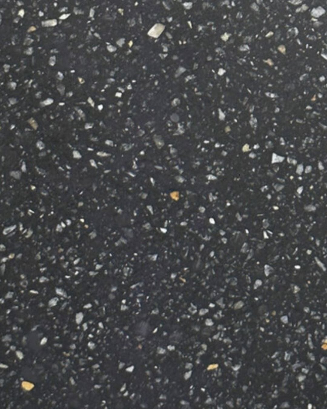 Close-up of a black textured surface with small white and gray specks