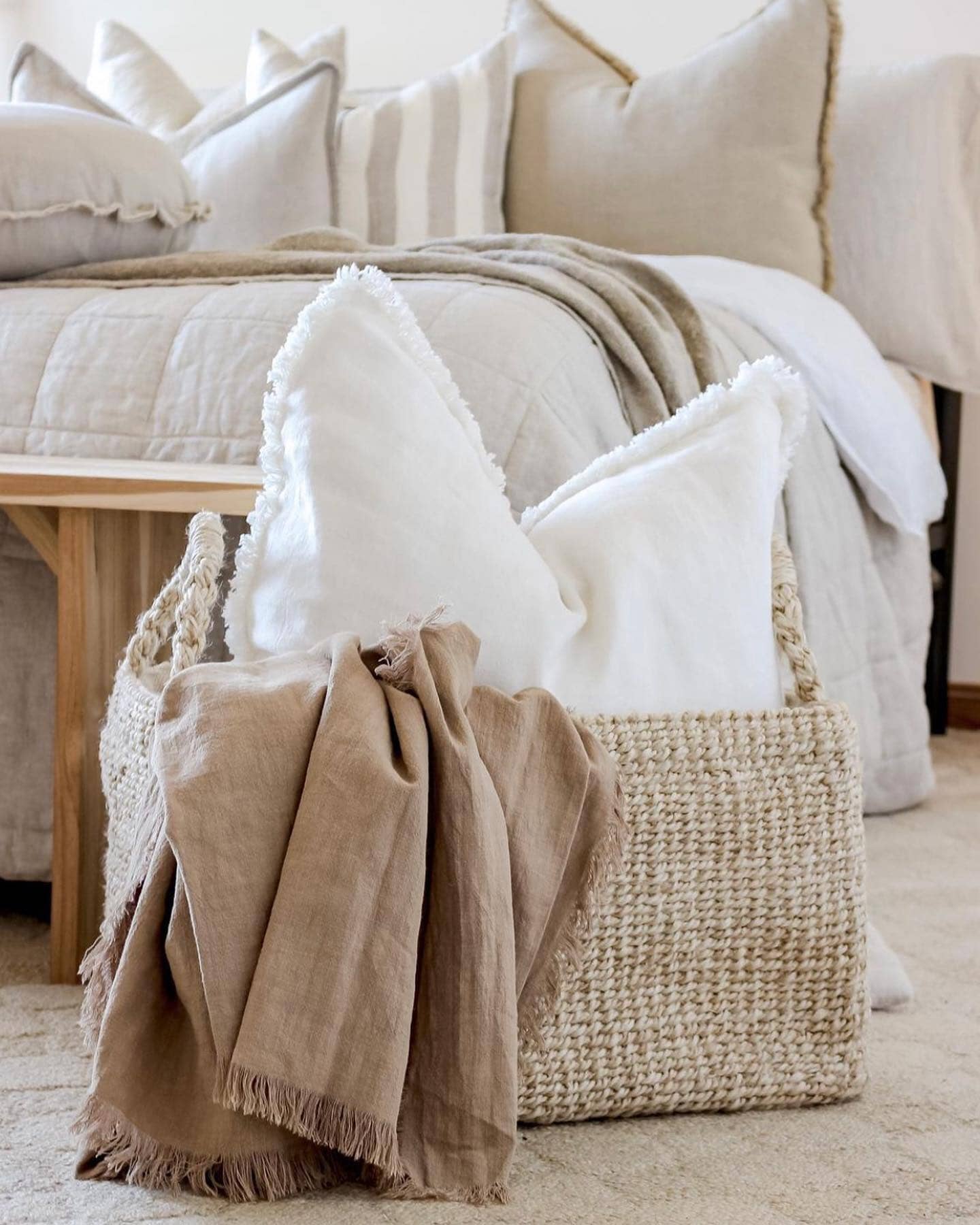 Chalk white ramie cushion cover with hand-finished fringe edges on modern neutral sofa