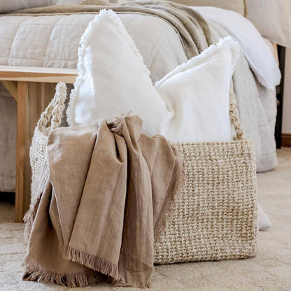 Chalk white ramie cushion cover with hand-finished fringe edges on modern neutral sofa