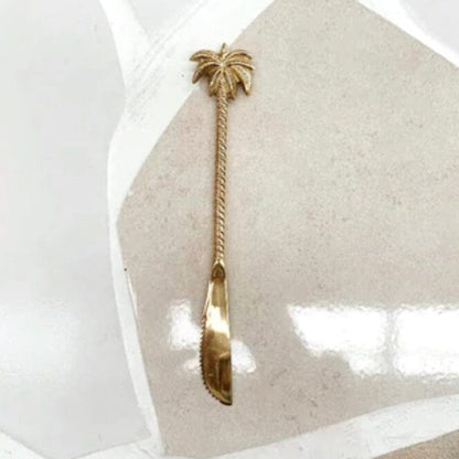 Gold knife with palm tree design on a white background